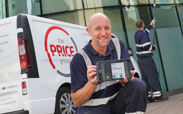 Man from The Price Group holding tablet