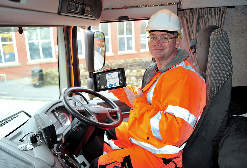 HTC Transport employee using a mobile BigChange device in his lorry.