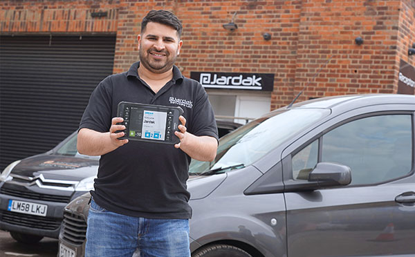 Jardak employee holding a JobWatch mobile device