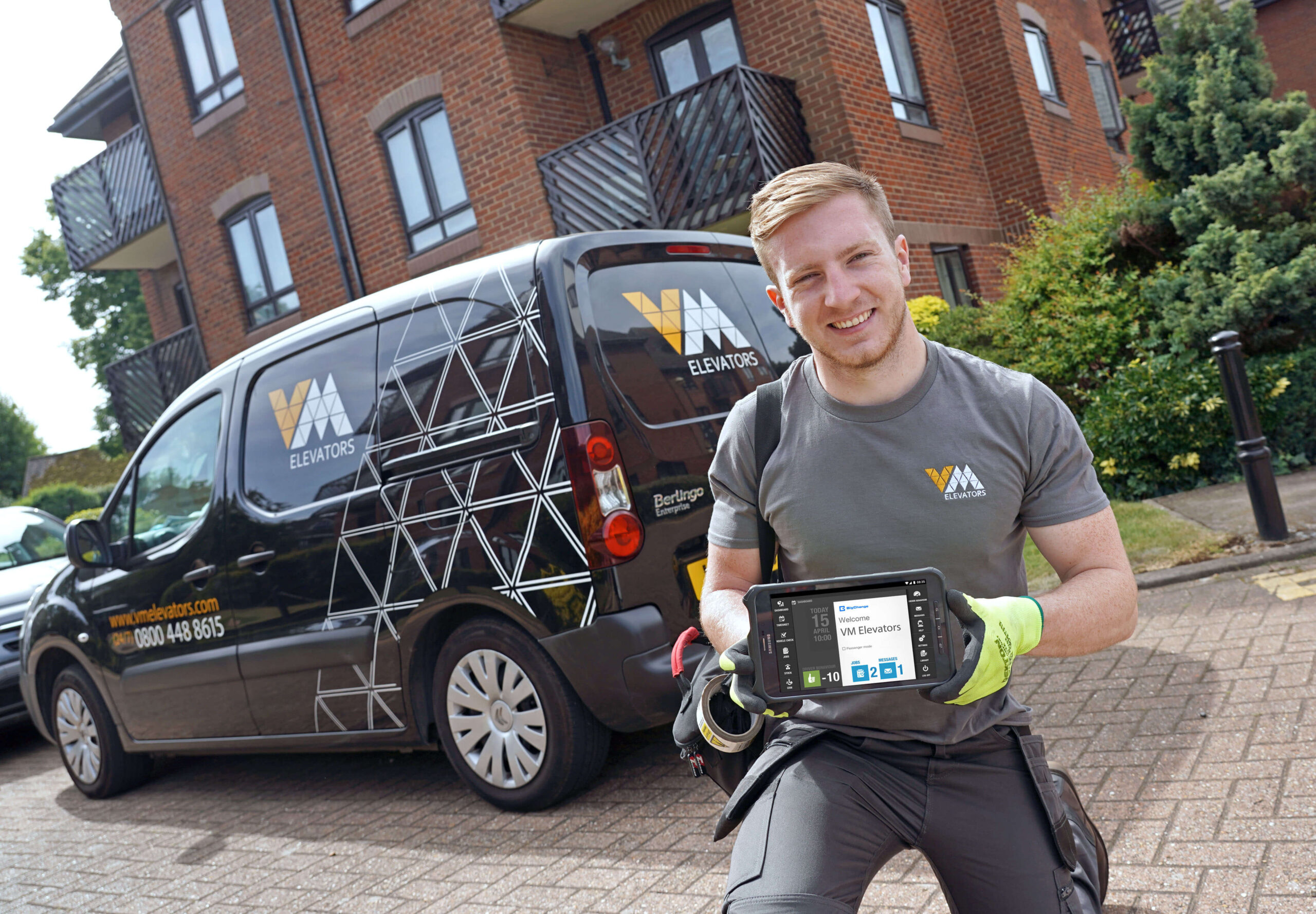 VME engineer holding BigChange tablet in front of van